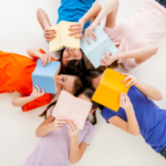 Five children laying on the floor each reading their own book.