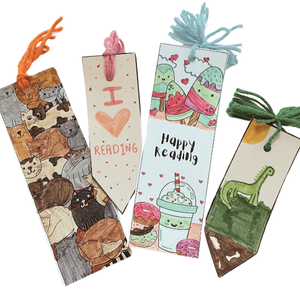Four handmade bookmarks with yarn pom poms on the ends.