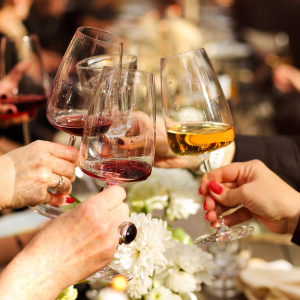 Three hands holding wine glasses together as a cheers!