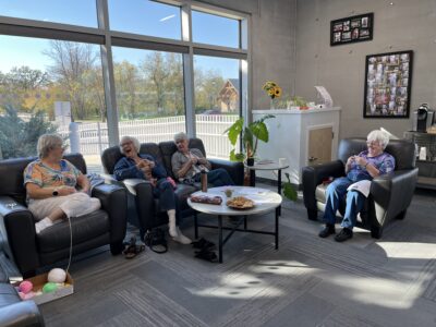 Community knitters and crocheters gathered together creating granny squares. 