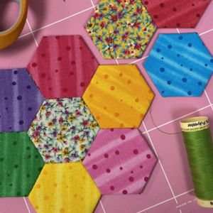 Colourful hexagons of fabric handsewn together.